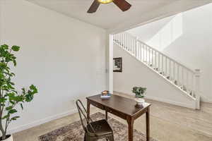 Office with ceiling fan and light colored carpet
