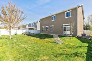 Rear view of property featuring a fenced backyard and stucco siding