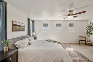 Carpeted bedroom featuring ceiling fan and baseboards