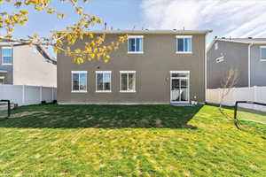 Back of property with a fenced backyard and stucco siding