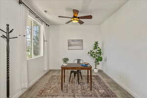 Home office with ceiling fan and light carpet