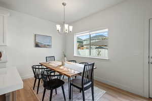 Dining area featuring light wood finished floors and a chandelier