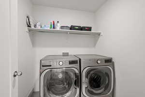 Laundry room with washer and clothes dryer and baseboards