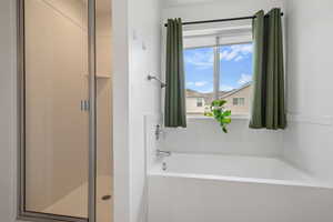Bathroom featuring a garden tub and a stall shower