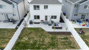 Back of property featuring outdoor lounge area, a patio, a fenced backyard, and roof with shingles