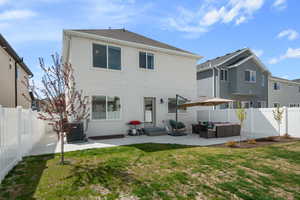 Back of property with a fenced backyard, a patio area, stucco siding, and outdoor furniture