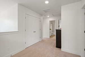 Unfurnished bedroom with light colored carpet, recessed lighting, and a closet