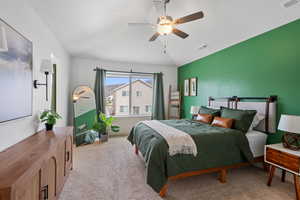 Bedroom featuring vaulted ceiling, light colored carpet, and a ceiling fan