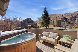 Wooden deck with outdoor lounge area, a hot tub, and a residential view