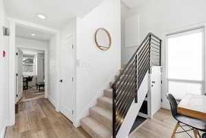 Stairs with wood finished floors and baseboards