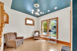 Living area with light wood-style flooring and suspended lighting