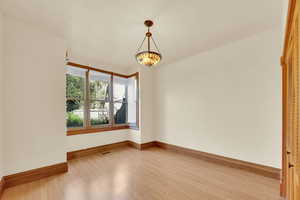 Unfurnished room with light wood-style flooring and baseboards