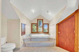 Full bath with a garden tub and lofted ceiling