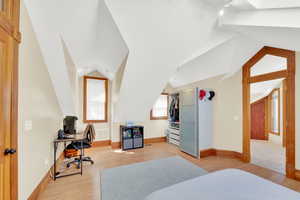 Bedroom with light wood finished floors and a desk