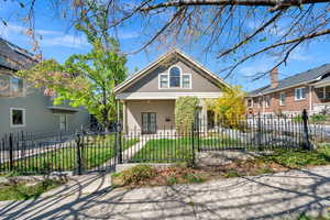 View of front of house featuring a gate, a fenced front yard, and a porch