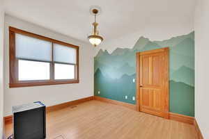 Additional living space featuring light wood-type flooring and baseboards