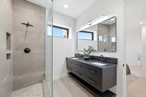 Full bathroom featuring double vanity, a walk in shower, and recessed lighting