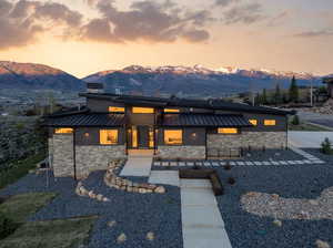 Modern home featuring stone siding, a standing seam roof, and a mountain view