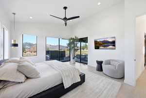 Bedroom with access to outside, a ceiling fan, recessed lighting, light wood-type flooring, and a high ceiling