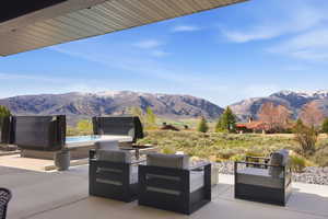 View of patio featuring a mountain view, outdoor lounge area, and a hot tub