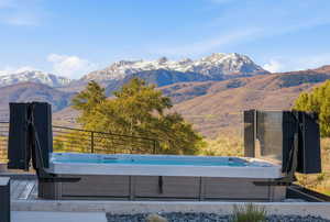View of pool featuring a hot tub and a deck with mountain view
