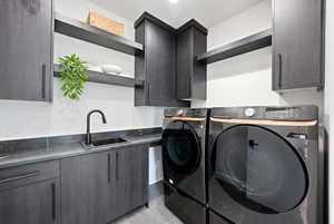 Laundry room featuring cabinet space, washer and dryer, and light tile patterned floors
