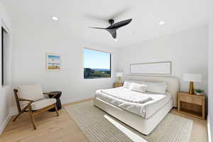 Bedroom featuring light wood-style floors, ceiling fan, and recessed lighting