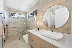 Full bathroom with vanity, tile walls, and a shower stall