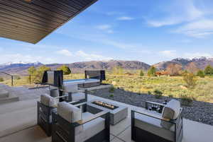 View of patio / terrace with a mountain view and an outdoor living space with a fire pit