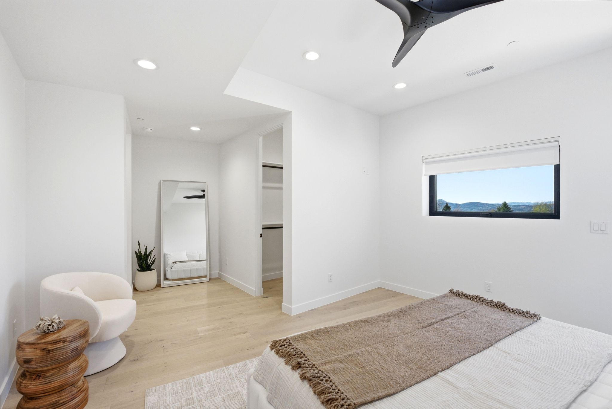Bedroom with light wood-type flooring, recessed lighting, a ceiling fan, and a walk in closet