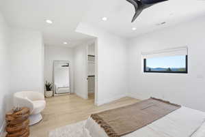 Bedroom with light wood-type flooring, recessed lighting, a ceiling fan, and a walk in closet