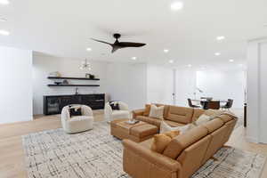 Living room with light wood-style flooring, recessed lighting, a ceiling fan, and bar area