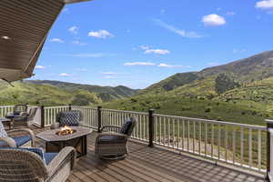 Wooden terrace featuring a fire pit and a mountain view