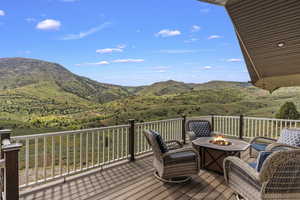 Deck with a fire pit and a mountain view