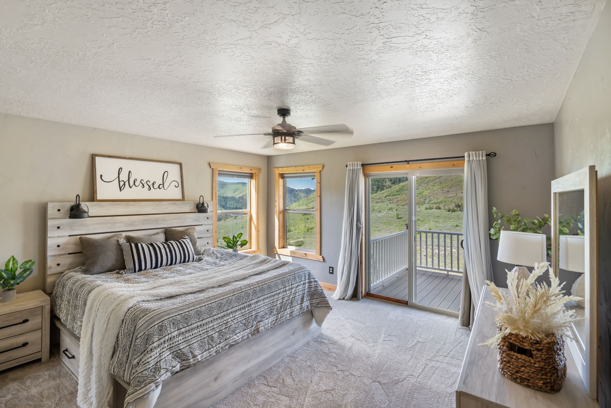 Bedroom featuring a textured ceiling, light colored carpet, access to exterior, and a ceiling fan