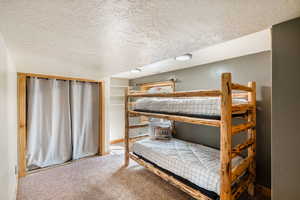 Bedroom featuring a textured ceiling and carpet
