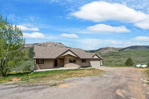 Single story home with driveway, a mountain view, and an attached garage