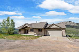 Single story home with driveway, a shingled roof, and an attached garage