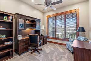 Office area featuring light carpet and a ceiling fan
