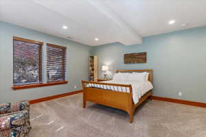 Bedroom with light colored carpet and recessed lighting