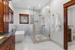 Full bathroom featuring a marble finish shower, vanity, light marble finish floors, a soaking tub, and recessed lighting