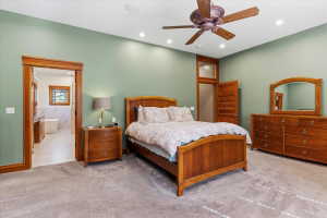 Carpeted bedroom featuring ceiling fan, recessed lighting, and connected bathroom