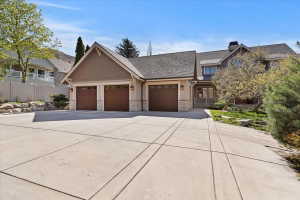 Craftsman inspired home with an attached garage, concrete driveway, stone siding, and a chimney