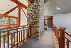 Corridor featuring an upstairs landing, lofted ceiling with beams, carpet, and recessed lighting