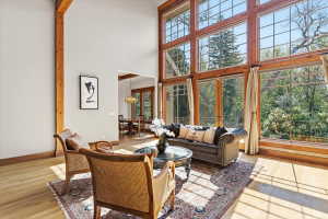 Living room featuring a high ceiling, light wood-style flooring, and hanging lights