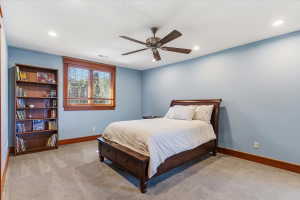 Carpeted bedroom with a ceiling fan and recessed lighting
