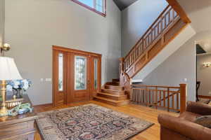 Entryway featuring healthy amount of natural light, light wood-style flooring, and a high ceiling