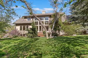 Rear view of house with a lawn, a chimney, and stucco siding