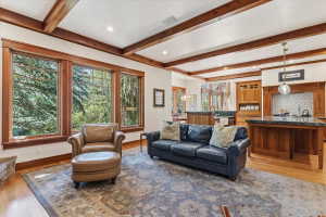 Living area featuring light wood-style floors, beam ceiling, plenty of natural light, and recessed lighting