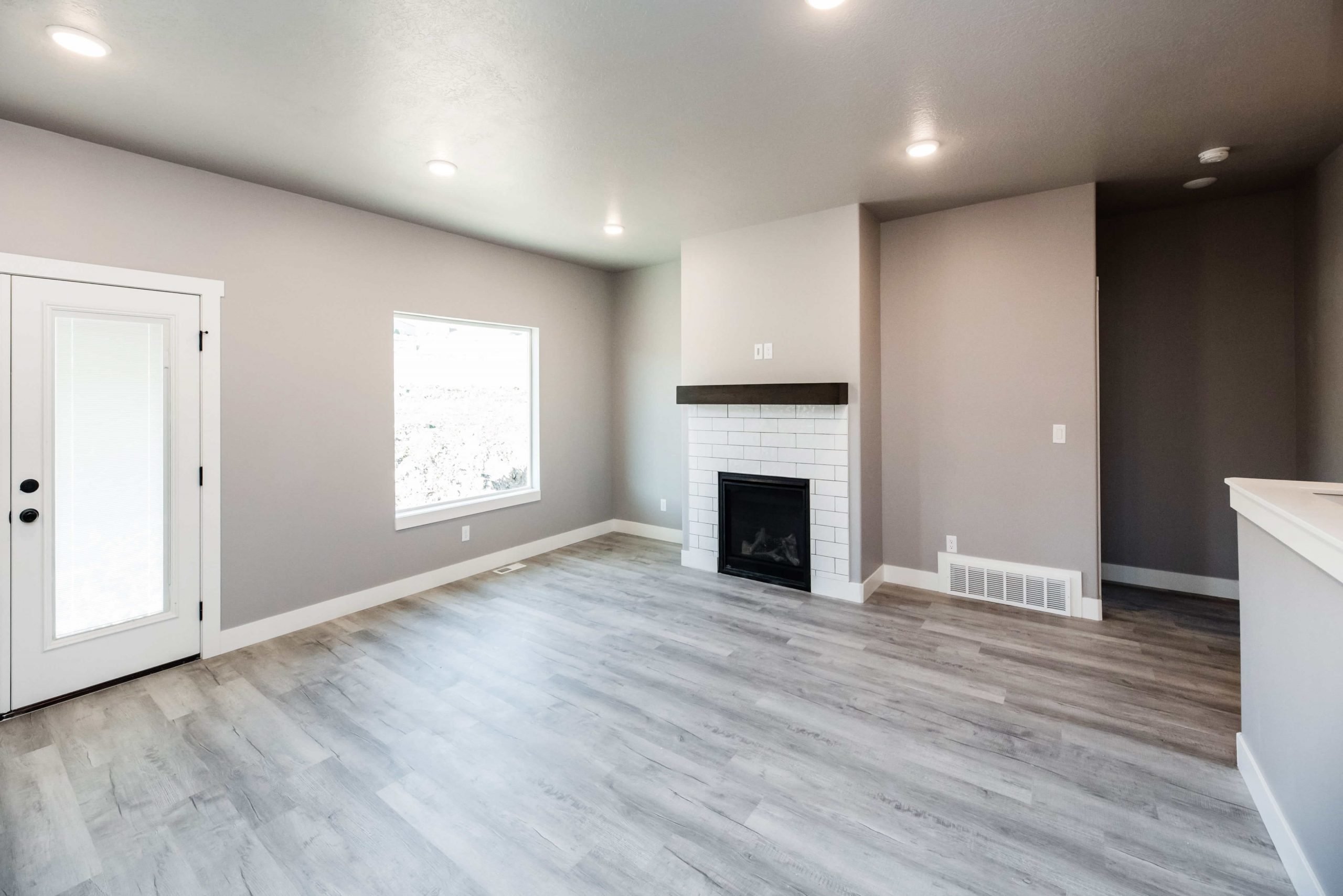 Unfurnished living room with a brick fireplace, light wood-type flooring, and recessed lighting